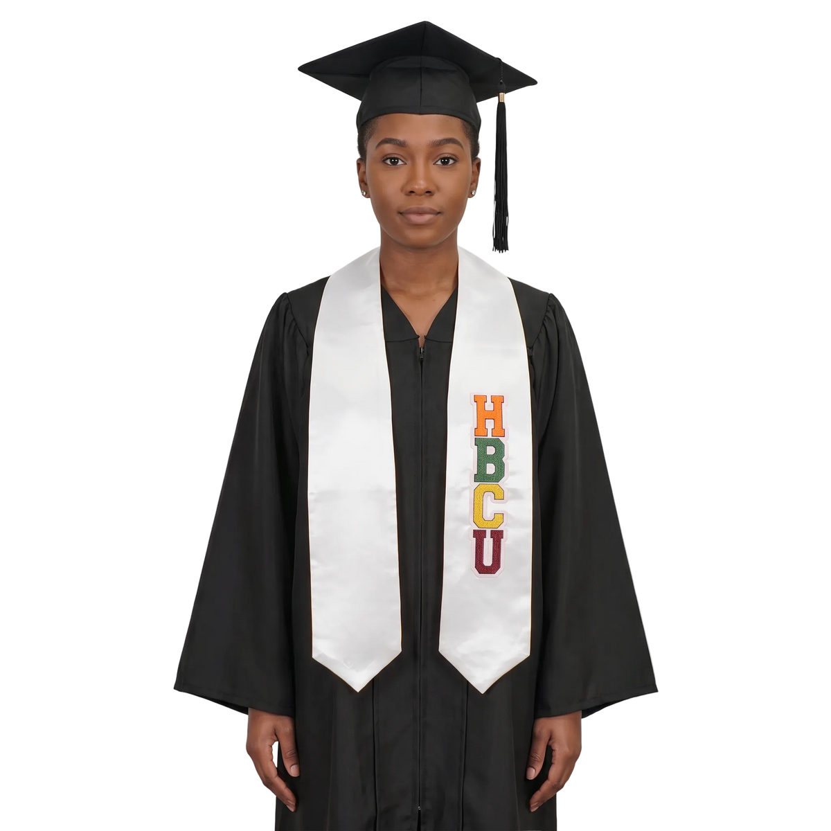 Graduate in a black cap and gown wearing a white HBCU graduation stole with vertically stacked multicolored HBCU lettering on one side and pointed ends.
