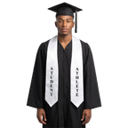 Graduate wearing a white Student Athlete graduation stole with vertical black “STUDENT” and “ATHLETE” lettering on opposite sides and pointed ends over a black graduation gown.
